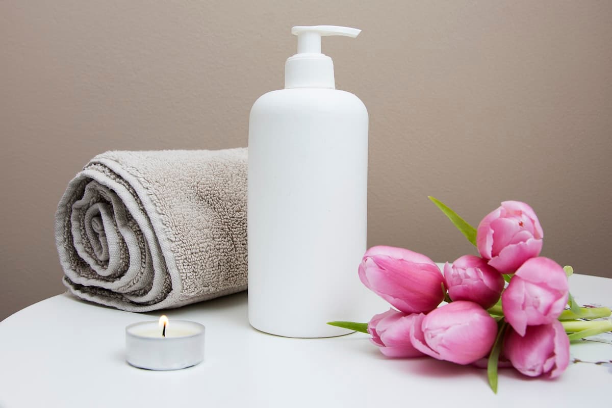 Rolled towel, candle and pink tulips on a table